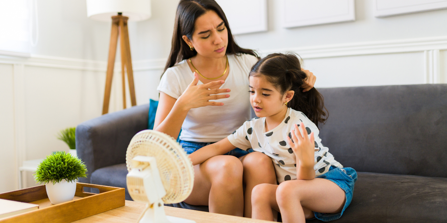 Mom and daughter in front of fan during heat wave - HOW ENSURE YOUR CENTRAL AIR CONDITIONING HANDLES CONSISTENT SUMMER HEAT WAVES